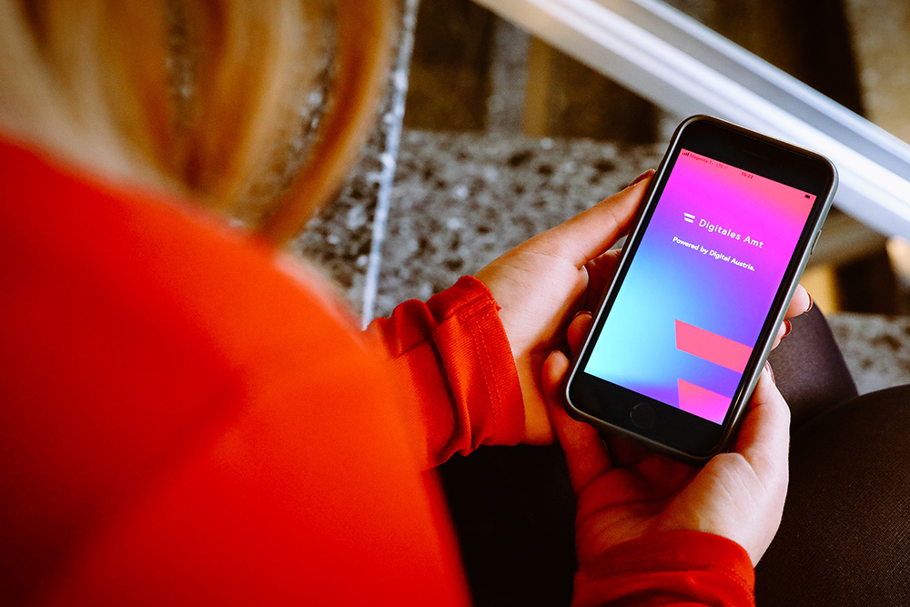Nutzerin mit Handy-Screen der App Digitales Amt